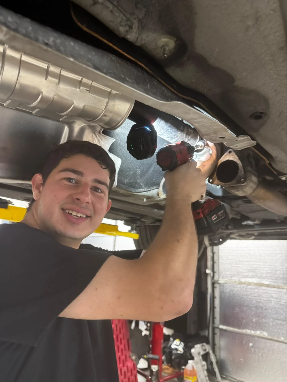 Josh inspecting and working beneath a vehicle